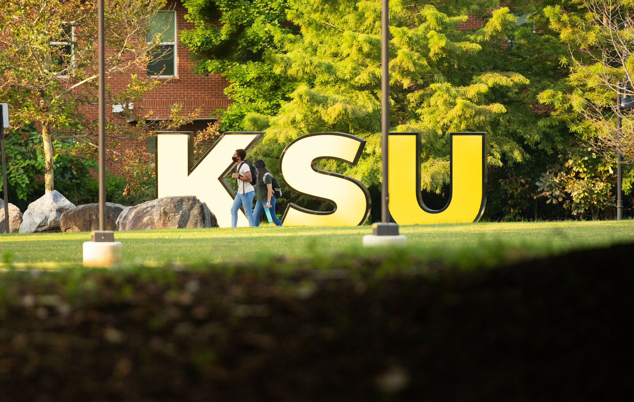 students walking by the KSU sign