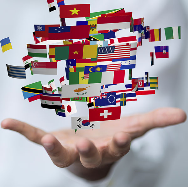 An individual holds a vibrant assortment of flags, representing different countrie