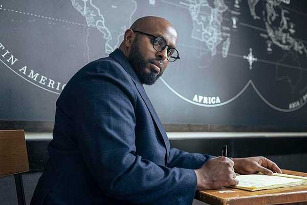 journalist at desk with globes on blackboard