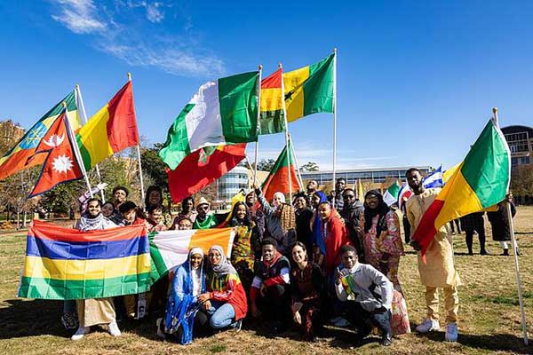 global students with flags outside on ksu campus