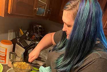 Meghan Cooper carefully straining ingredients for a dish.