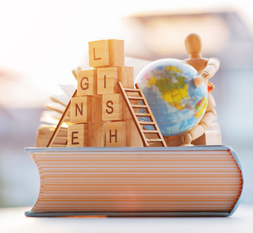 A conceptual image representing English education, featuring wooden letter blocks spelling "ENGLISH" stacked on top of a large book.