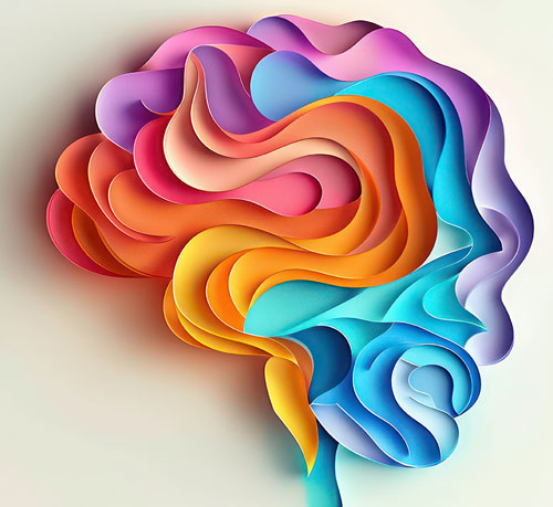  A vibrant, abstract representation of a human brain made from layered, multicolored paper cutouts in shades of blue, orange, pink, and purple.