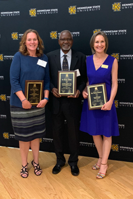 Dr. Susan Raines, Dr. Akanmu Adebayo, and Ms. Nicole Densmore pose with their awards at the annual KSU Awards Ceremony