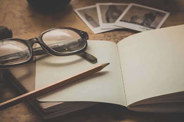 open book, glasses, pencil and pictures on desk