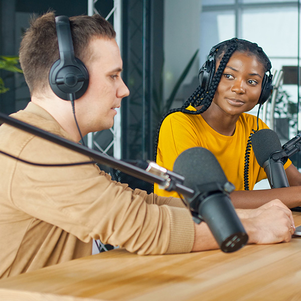 man and woman with microphones on podcast