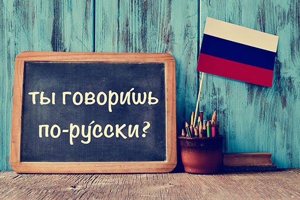 speak russion written in russian on chalk board with flag