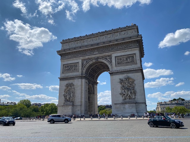 The Arc de Triomphe in Paris, a monumental arch honoring military victories, stands majestically against a clear blue sky.