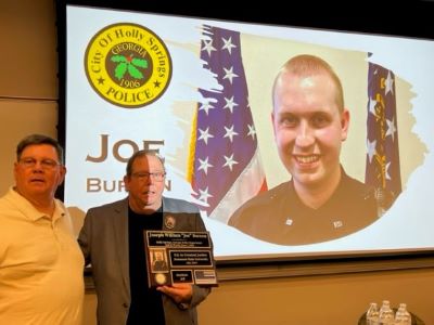 Family of officer Joe Burson, holding a plaque in memory of him.