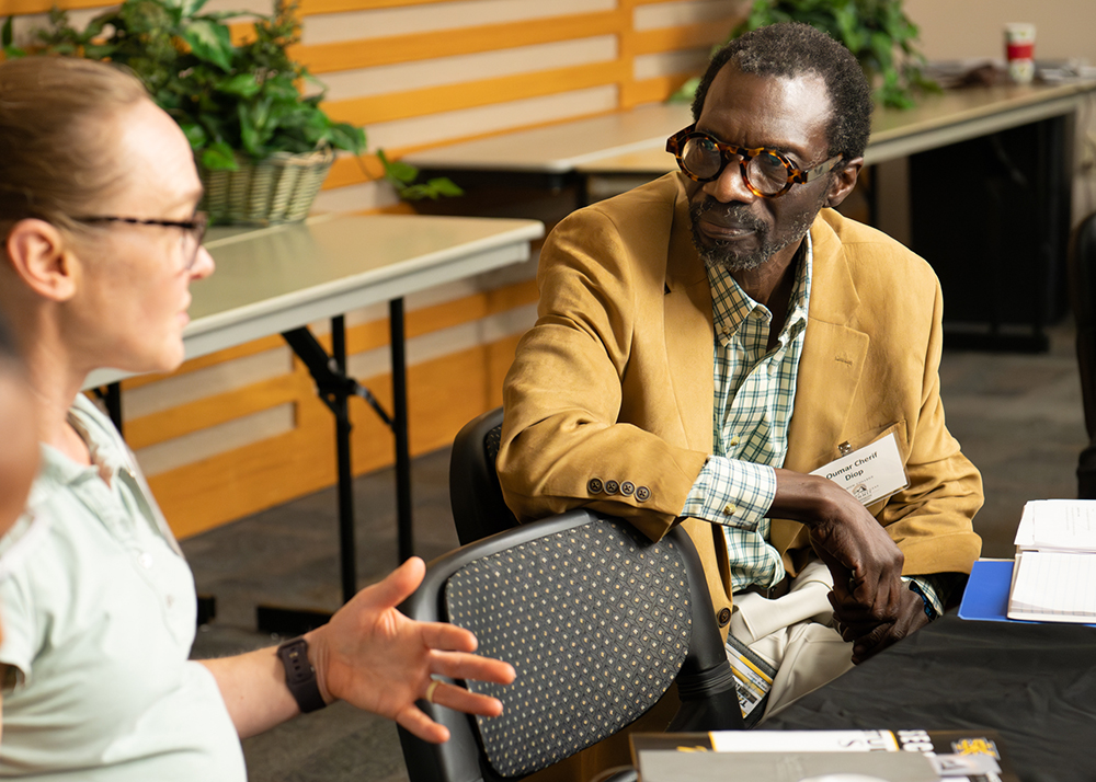 Man listening to woman at table at student success summit