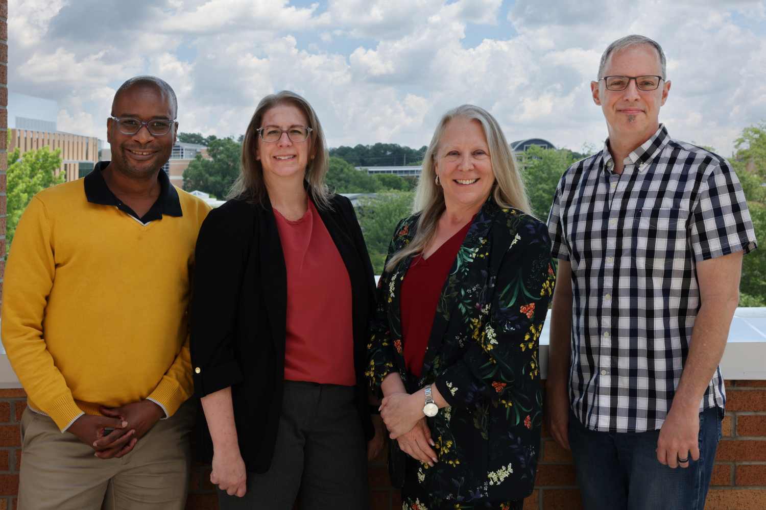 Jeffery Jackson, Kris DuRocher, Dean Katie Kaukinen and Matt Waller standing on a balcony.