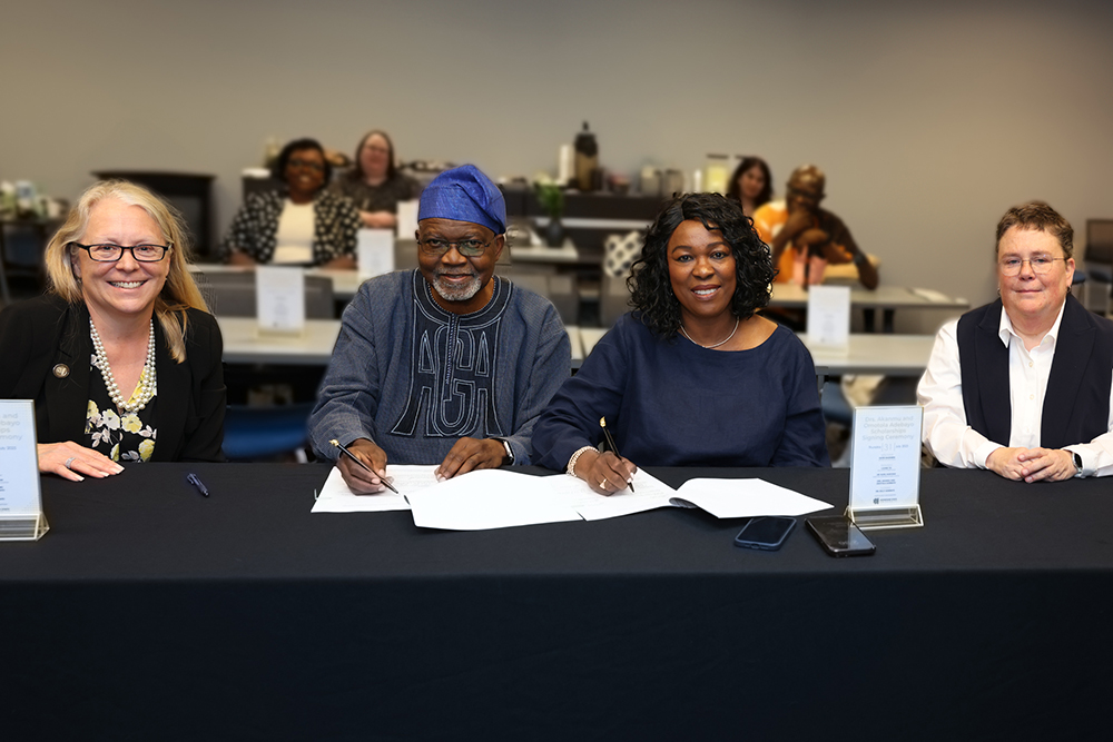 Dean Catherine Kaukinen, Dr. Akanmu G. Adebayo, Dr. Omotola A. Adebayo and Dean Laurie Tis at table at scholarship signing