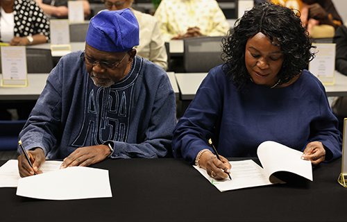 Dr. Akanmu G. Adebayo and Dr. Omotola A. Adebayo signing the Akanmu G. and Omotola A. Adebayo International Student Scholarship