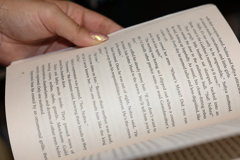close up on female hands as he has book open