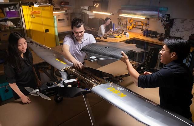 Students working on assembling a large drone in a university robotics lab.