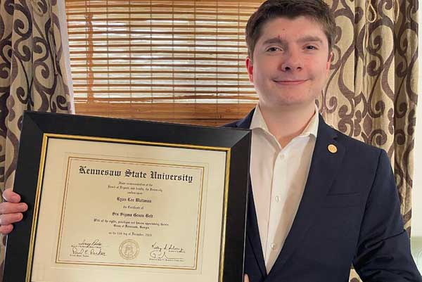 ksu student holding framed certificate
