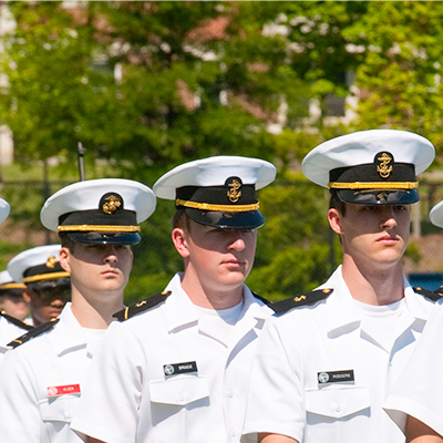 naval men posing in photos outdoors in white hats