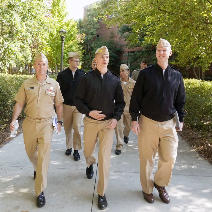 men walking outside next to eachother in navy outfits