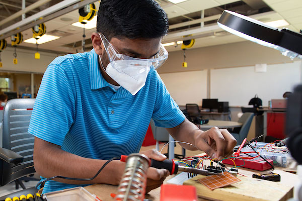 student working on project with soldering iron