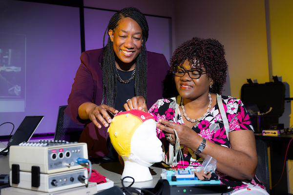 professor and student looking at a brain model
