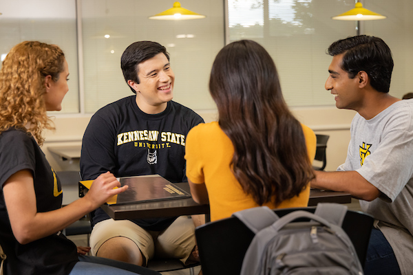 four students at table being social
