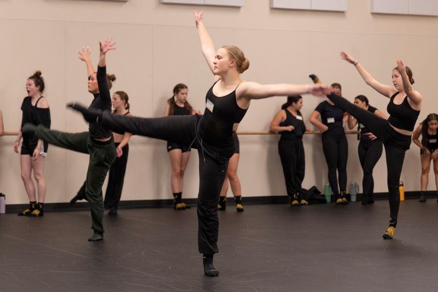 A group of dancers practicing together in a bright and spacious dance studio, showcasing their movements and teamwork.