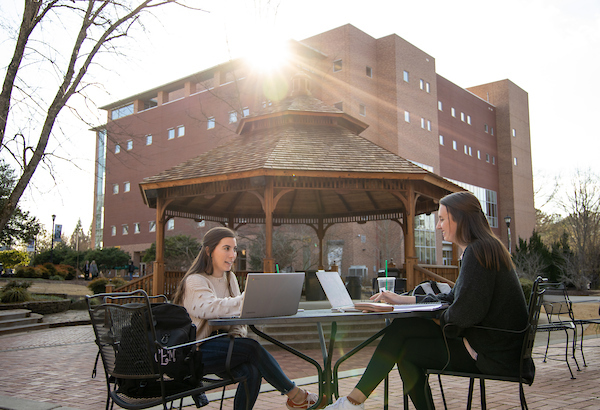 students at a table outside on campus