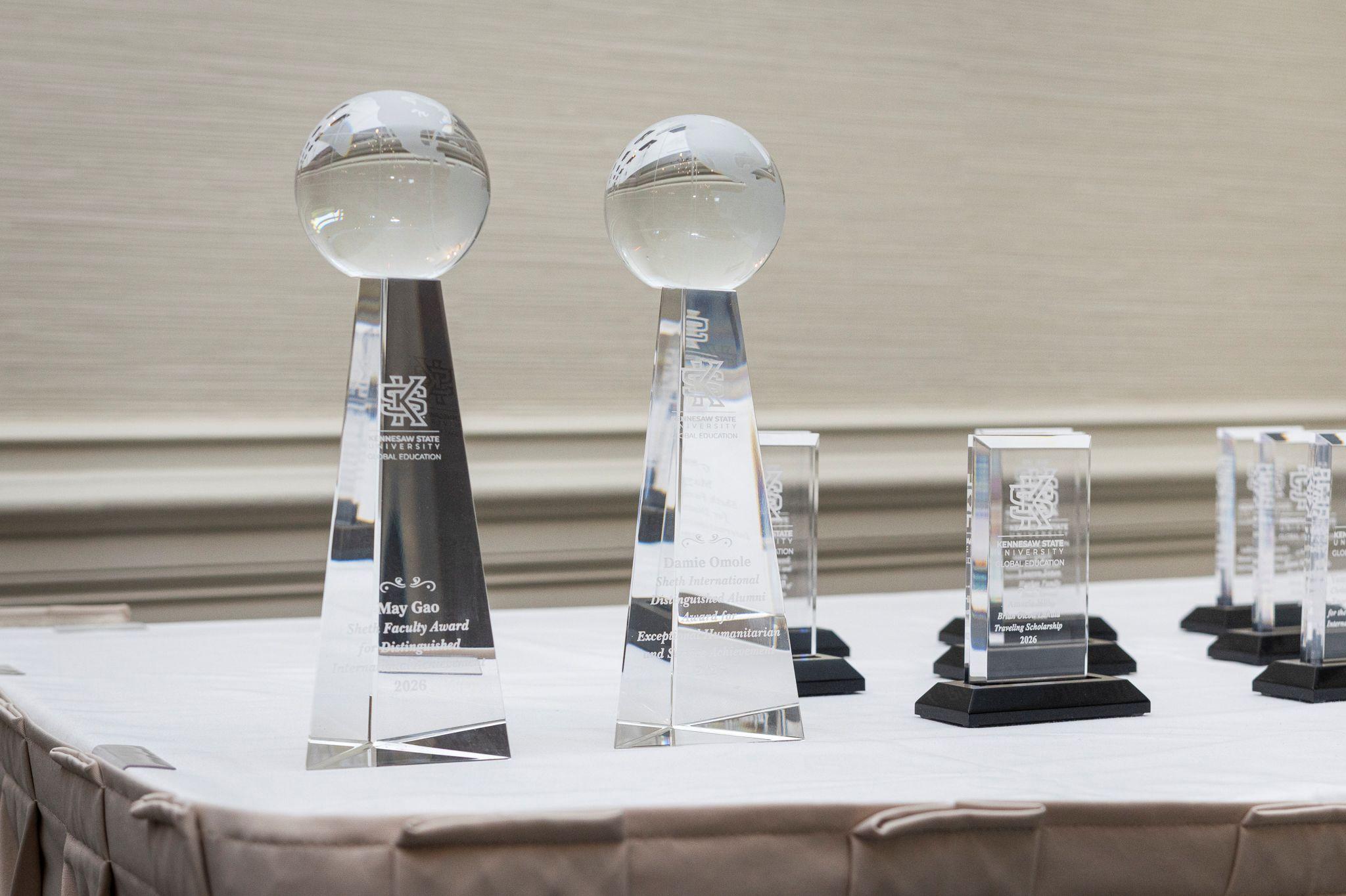 International Achievement Awards and Scholarship Ceremony 2026 / Two crystal awards on a table. 