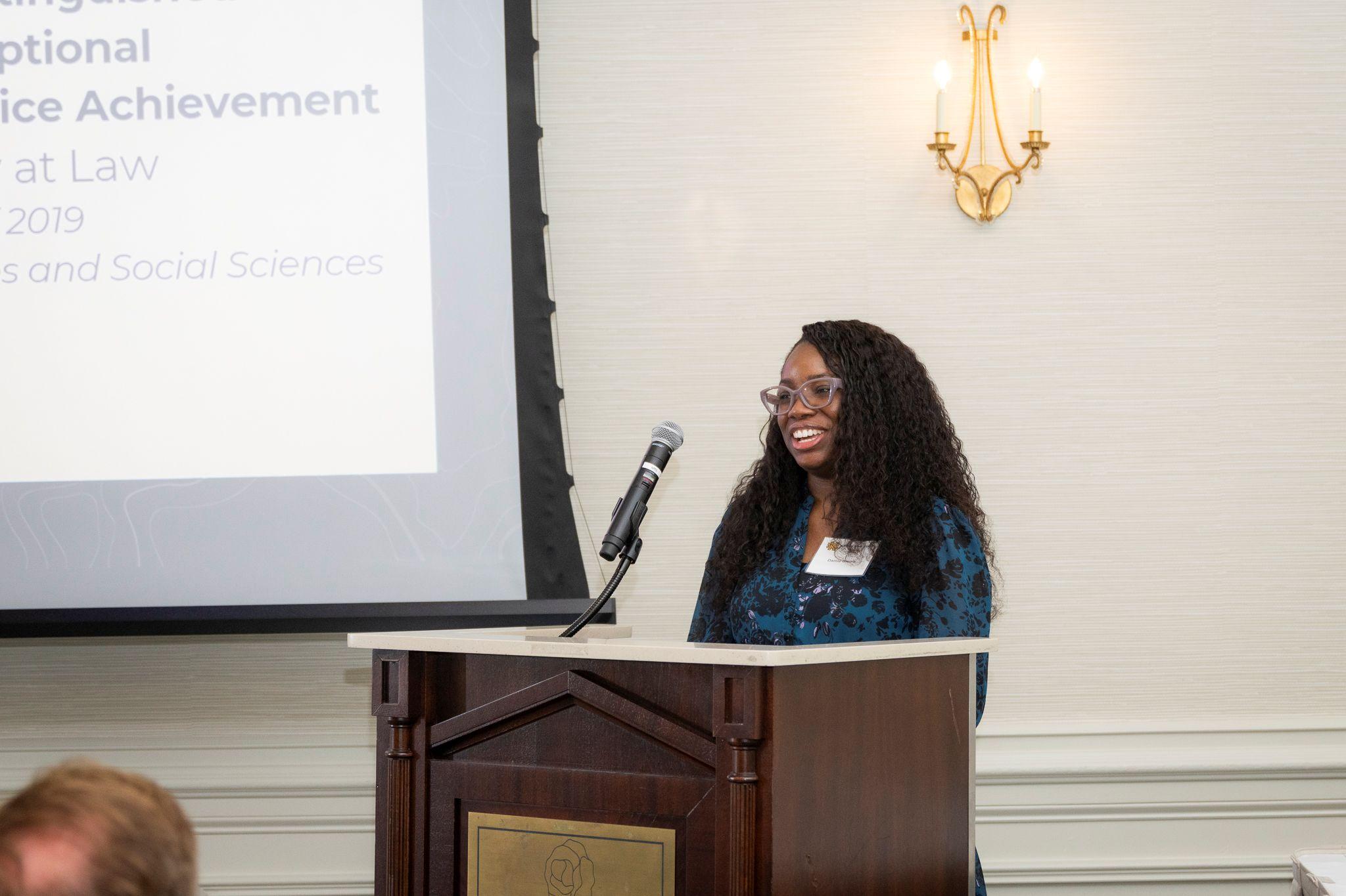 International Achievement Awards and Scholarship Ceremony 2026 / Damie Omole speaking behind a podium. 