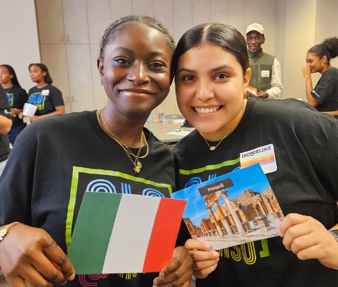 Two girls smiling and standing close together at an event