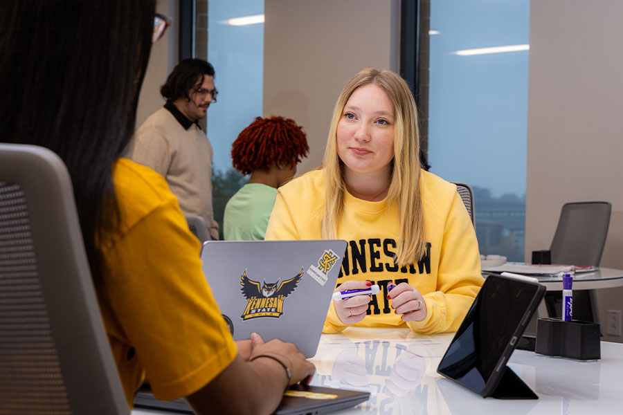 female student sitting at table studying in KSU's smart center