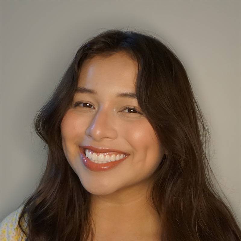 Professional headshot of Jane with long dark hair against a light background.