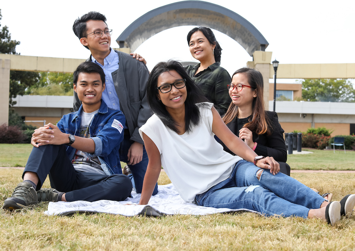 international students sitting on the campus green.