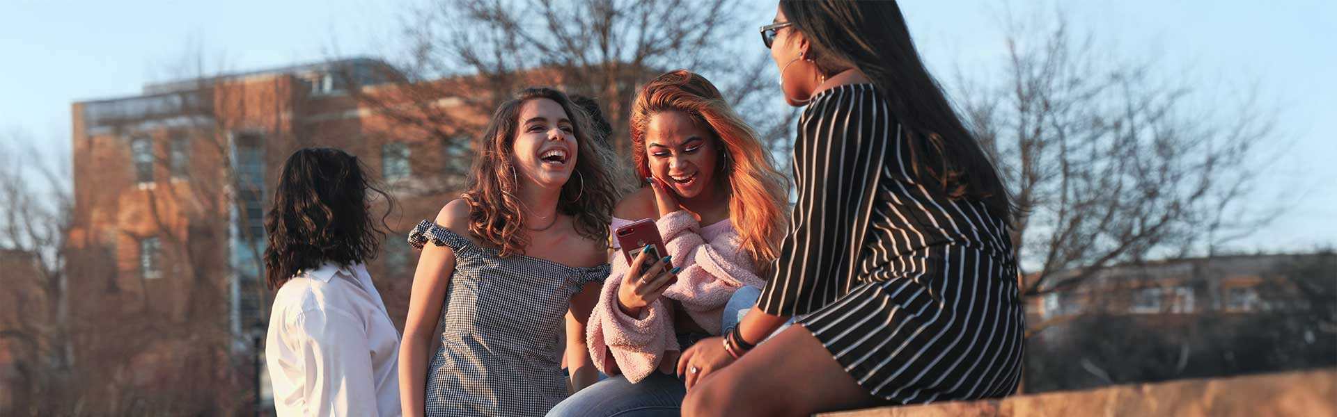 group of ksu students laughing and hanging out on campus.