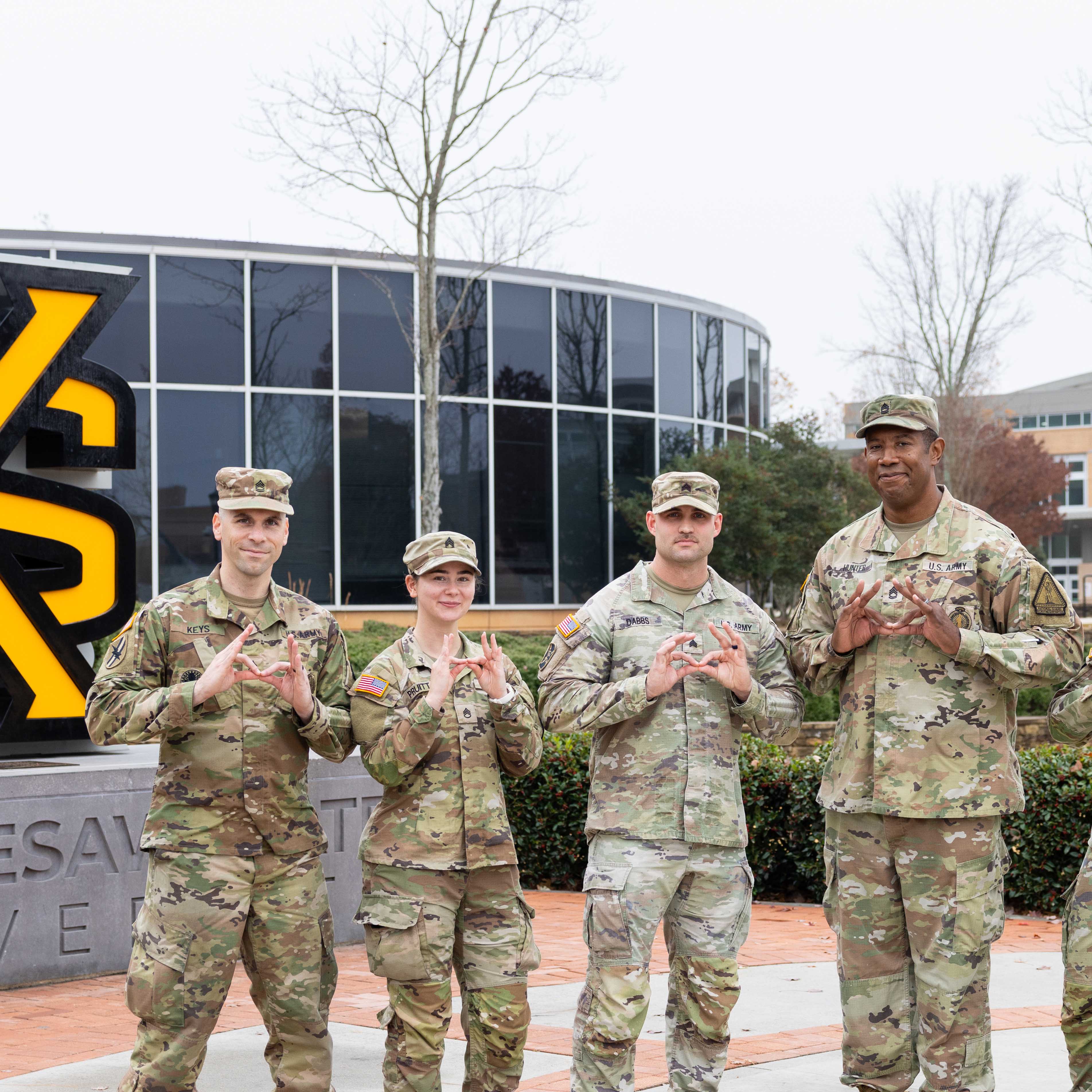 group of military men standing in front of ksu's sign
