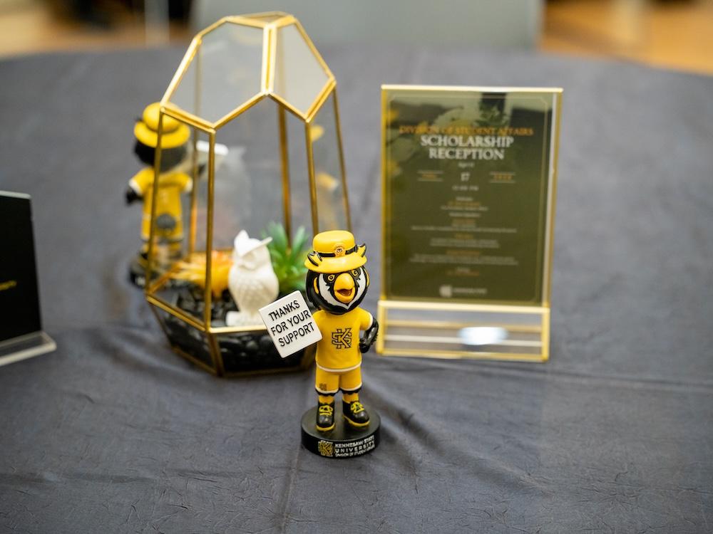  / A Scrappy bobblehead sitting on a table in front of a run-of-show. 