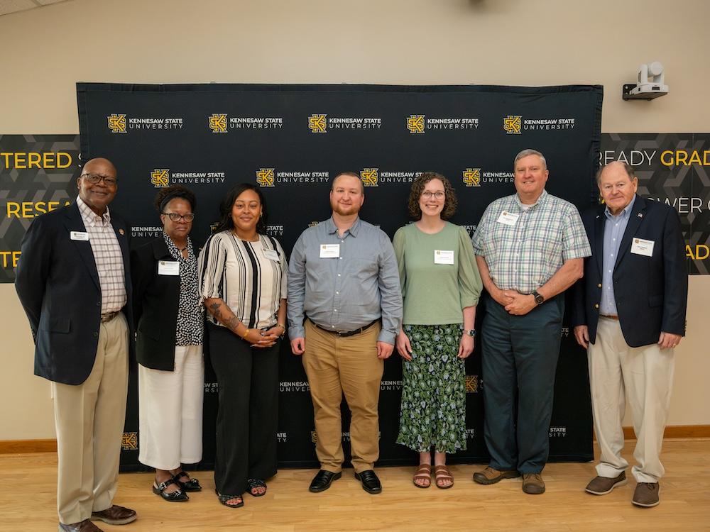  / Student Affairs donors pose in front of a KSU-branded wall. 