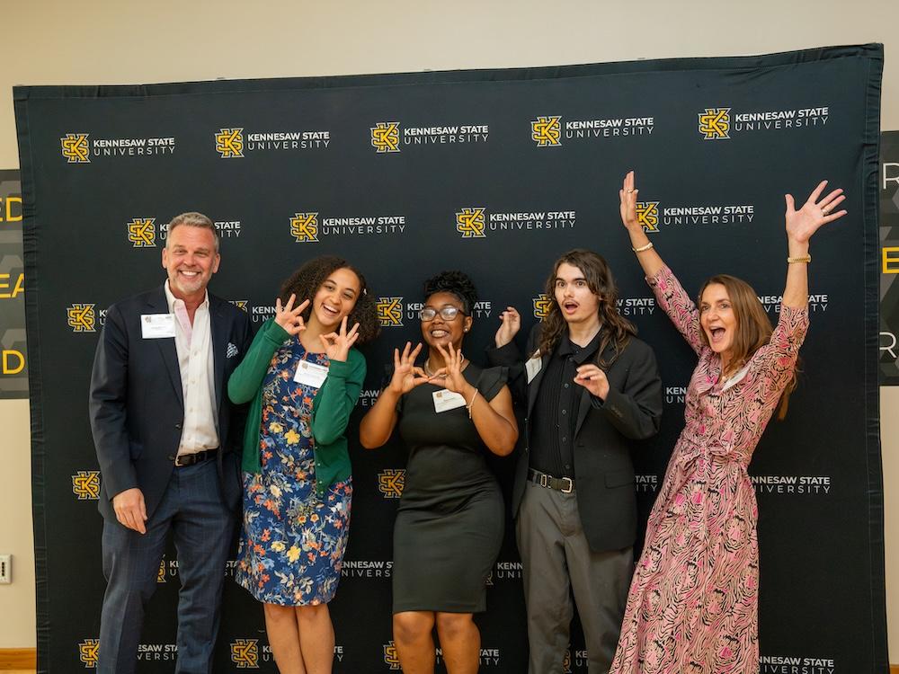  / Student Affairs donors pose in front of a KSU-branded wall. 