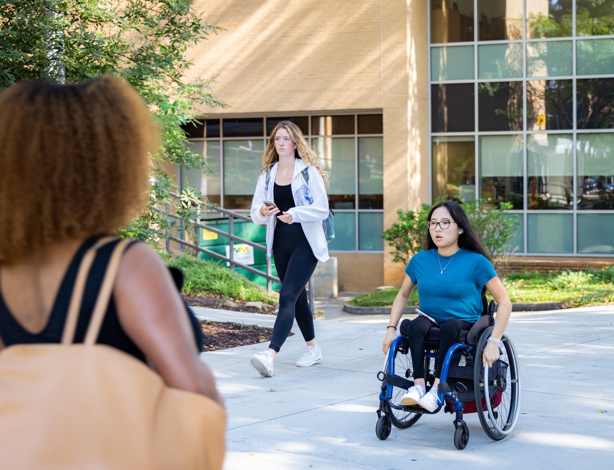 students in wheelchair on path
