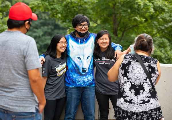 Parents taking pictures with their student