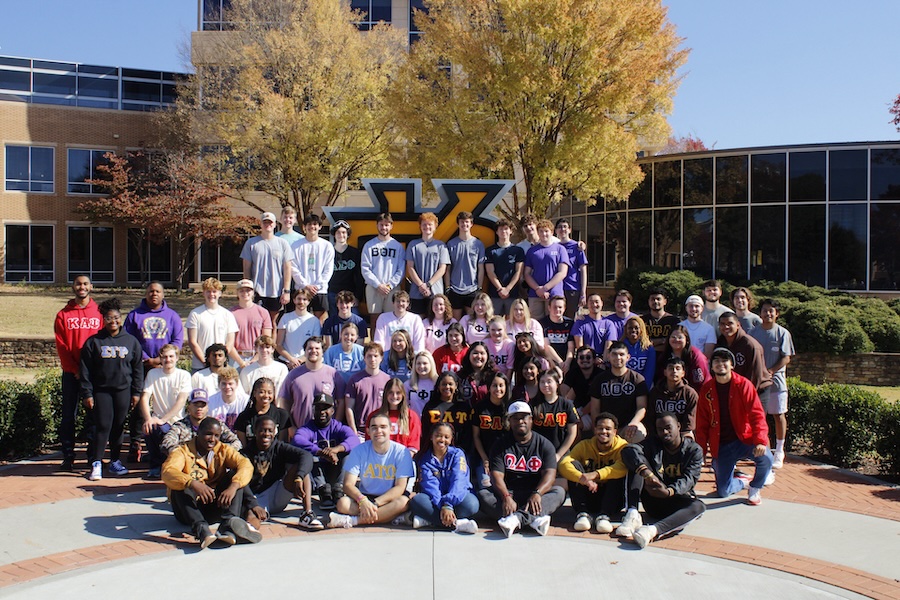 group of Greek Life students standing by the ksu sign on campus.