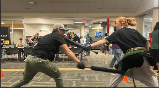Two students participating in Live Action Roleplay inside of the Wilson Student Center for Owl Con.