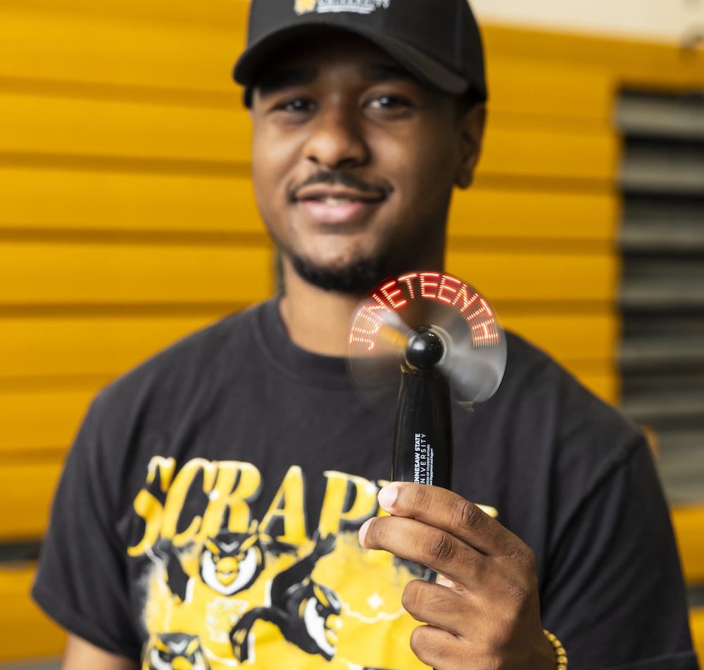KSU Student posing with a Juneteenth fan.