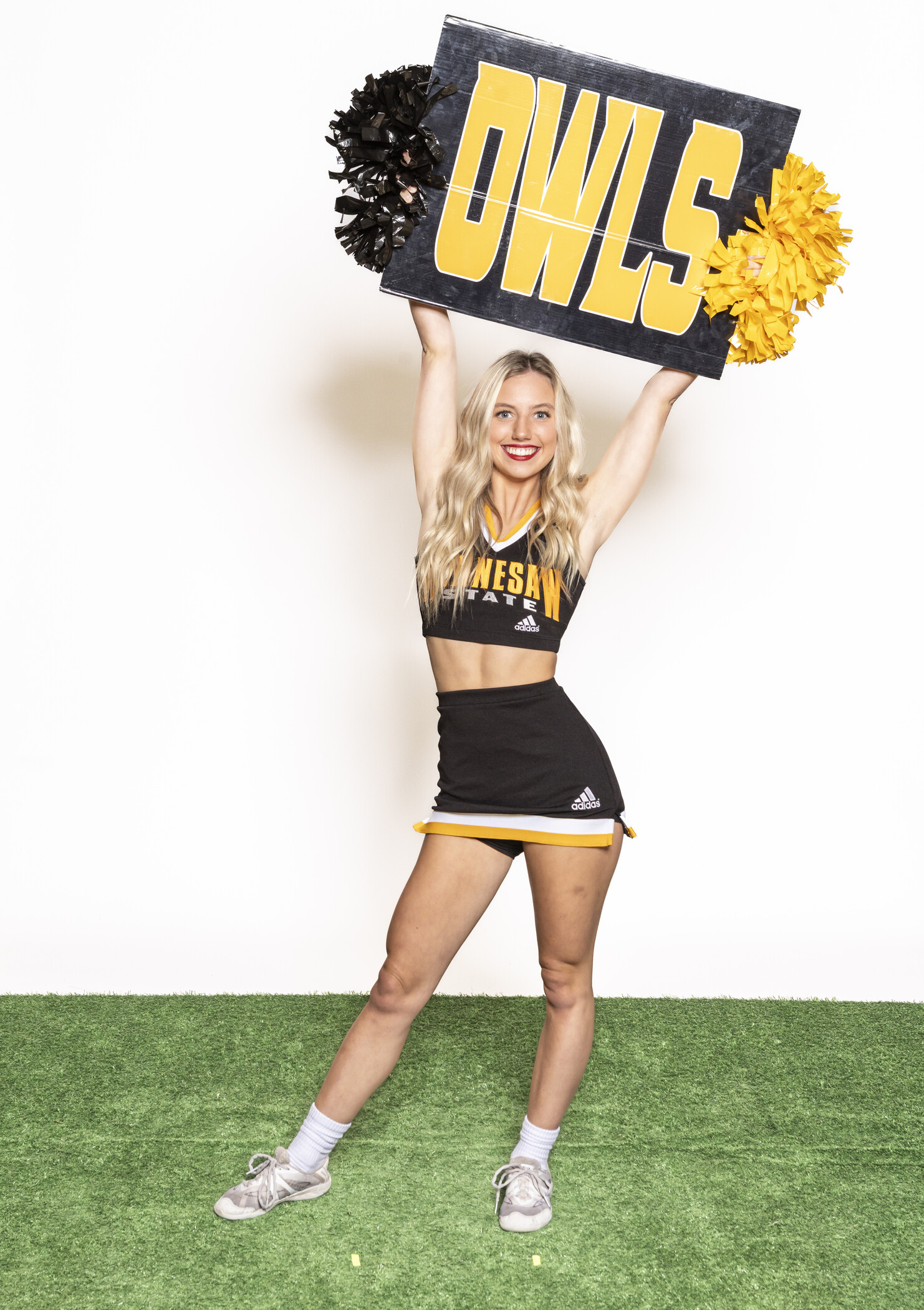 cheerleader holding owls sign