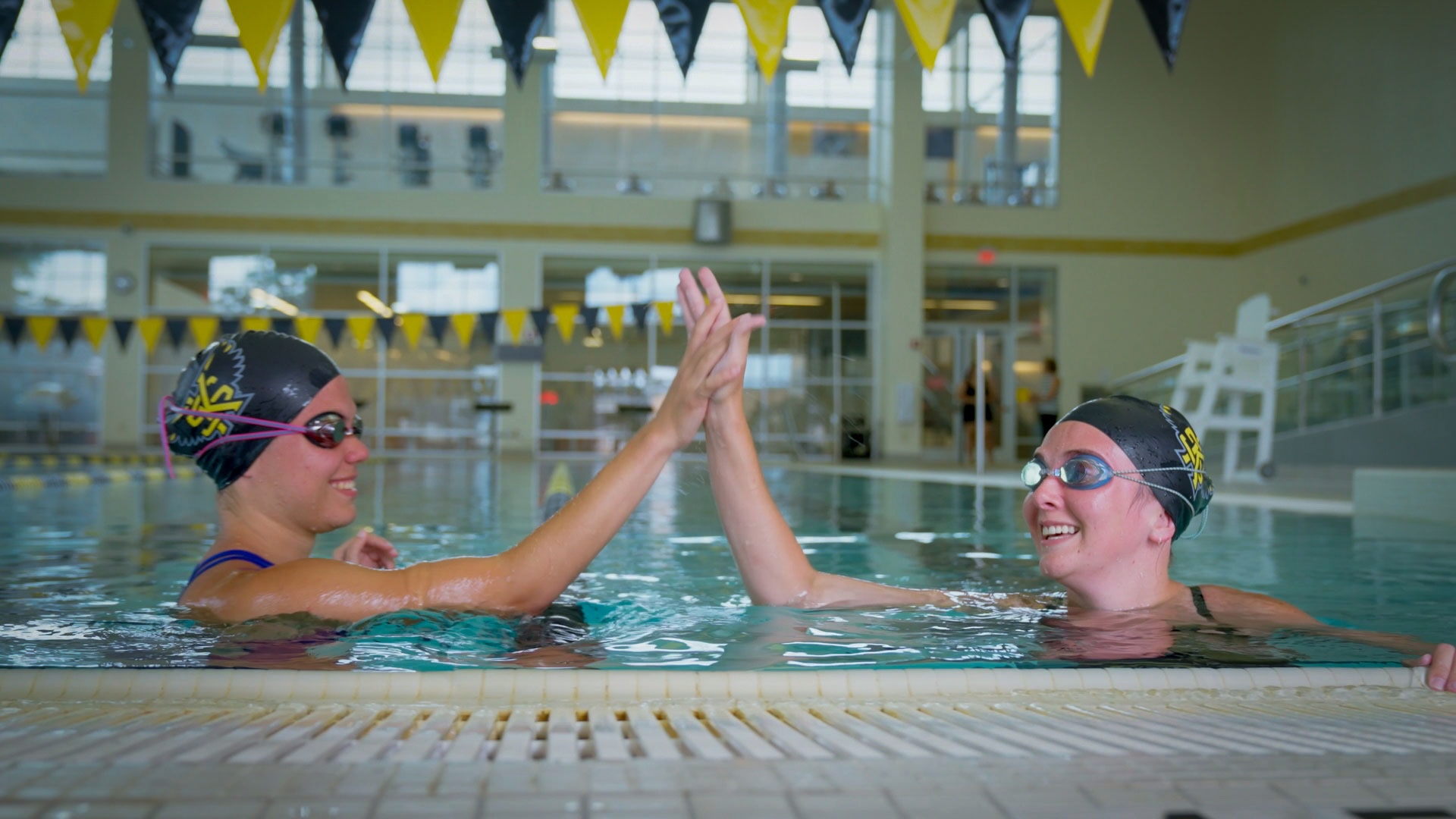 students high fiving in the pool