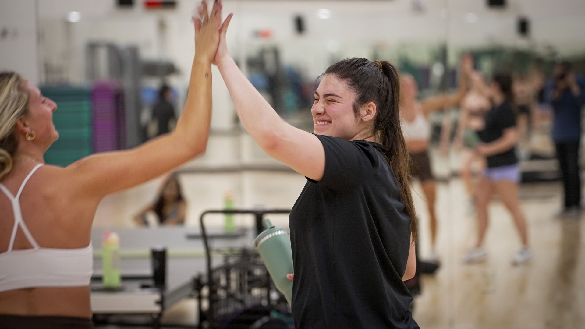 Students high fiving during fitness class