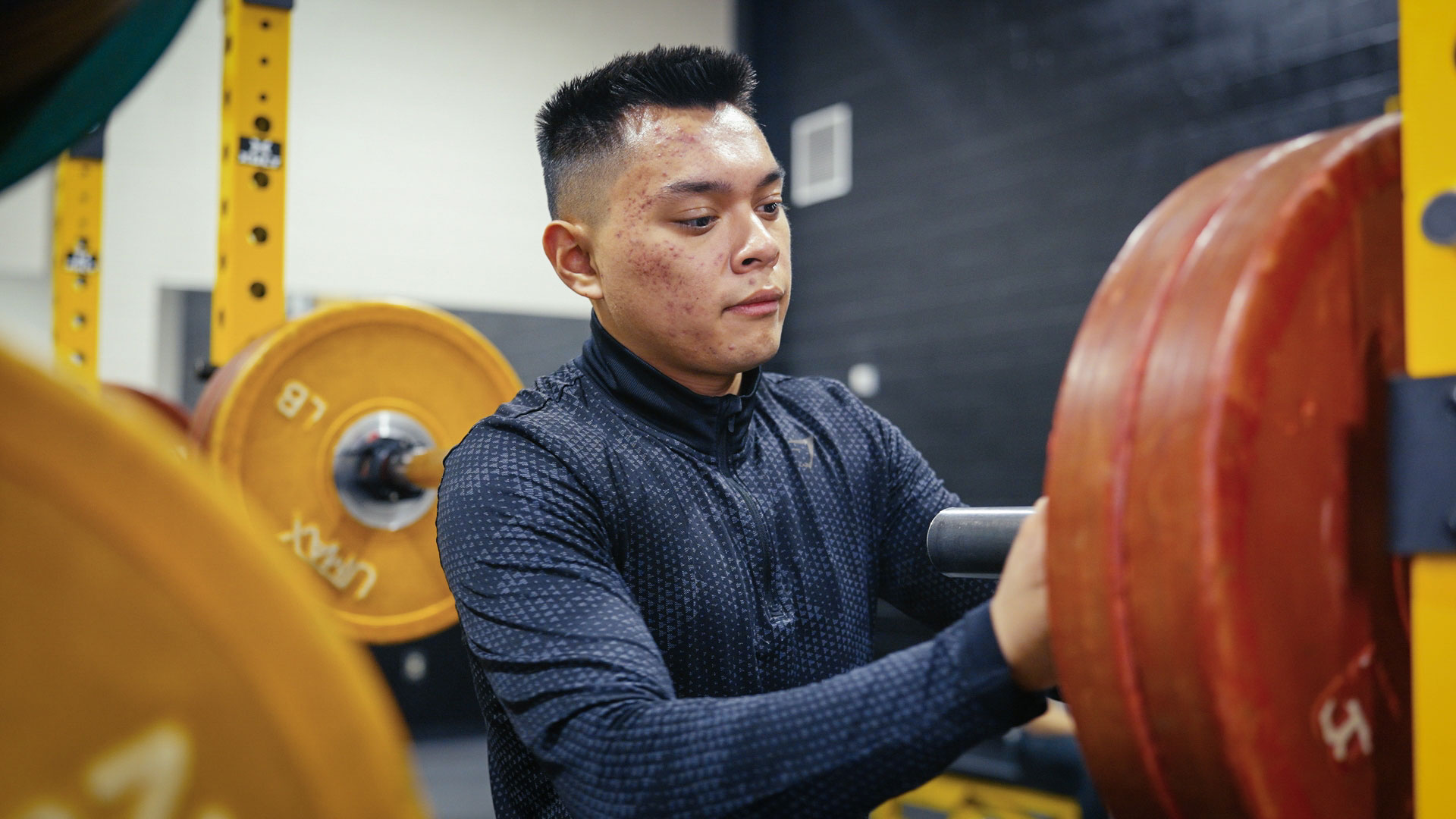 Student setting up weight rack