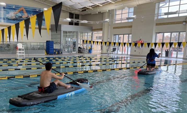 ksu students on paddleboard in indoor pool