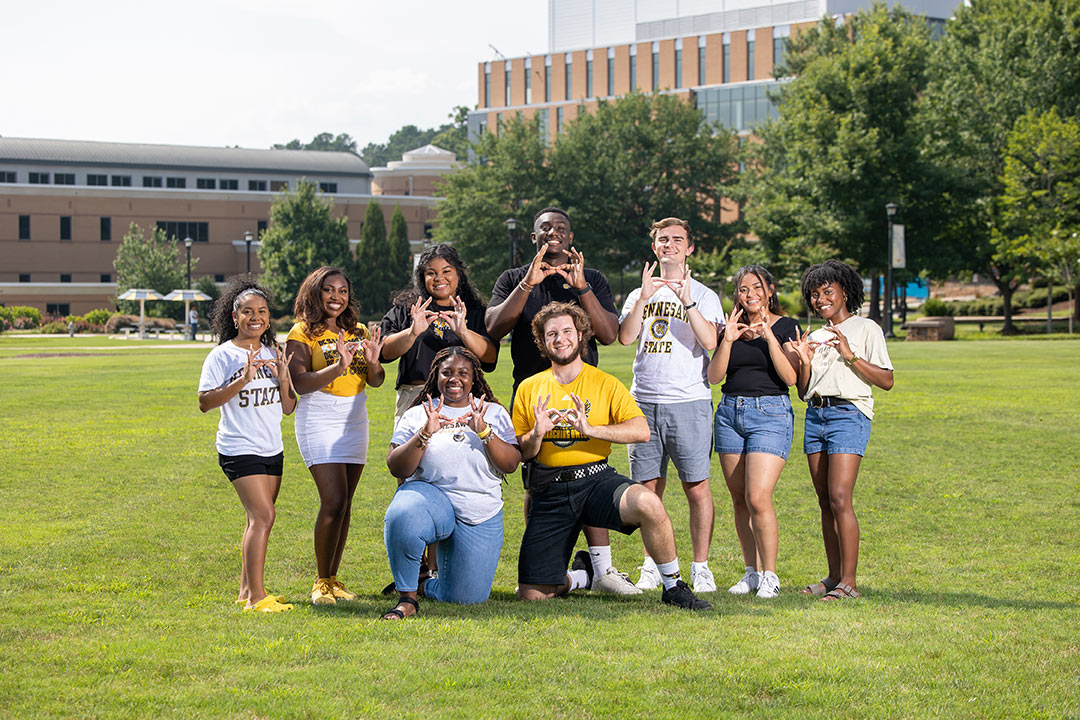 group of students posing together on the Campus Green