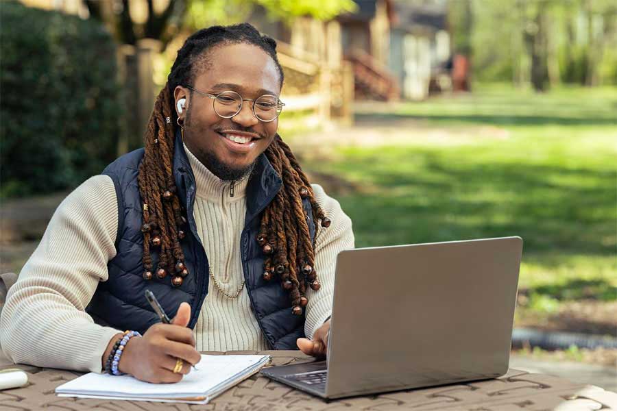 ksu outdoors using their laptop.